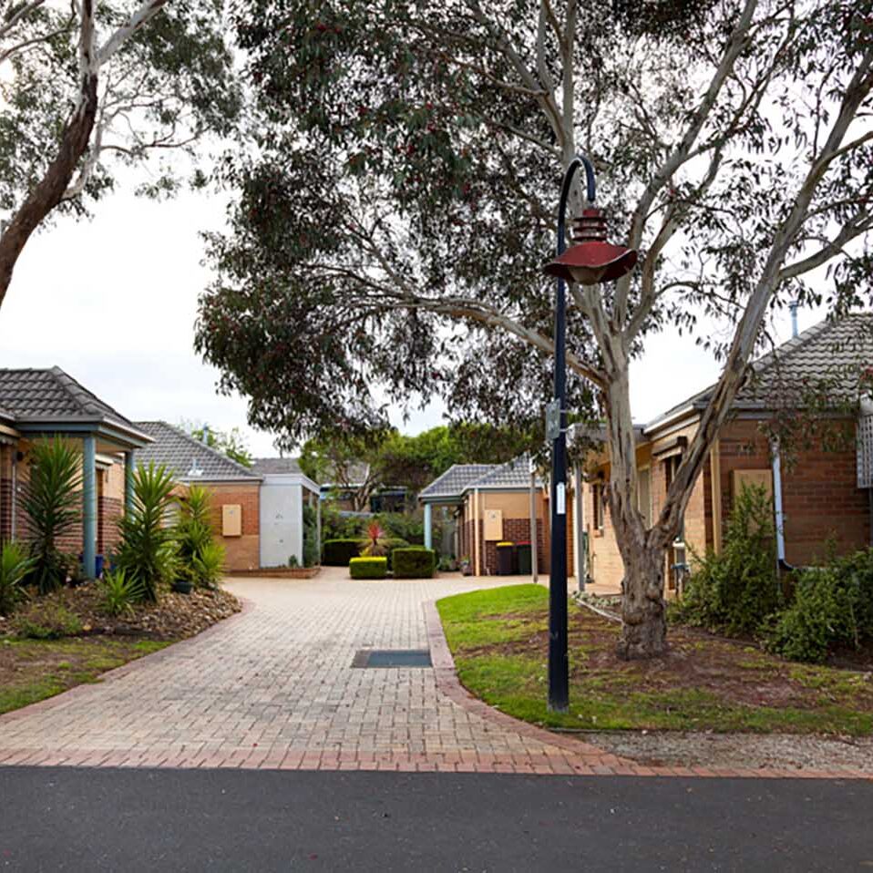 A driveway leading to a row of houses in a retirement village.