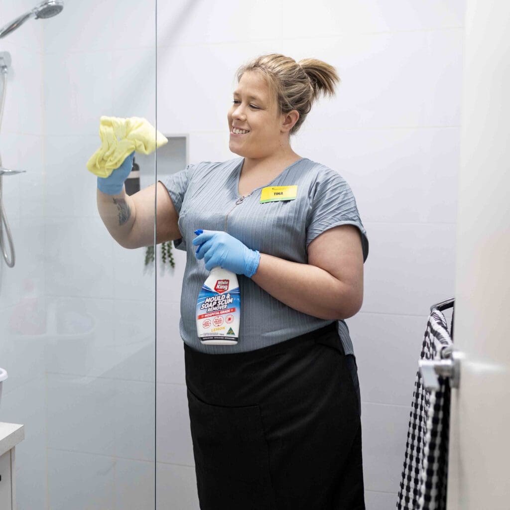 A woman cleaning a shower in a retirement home.