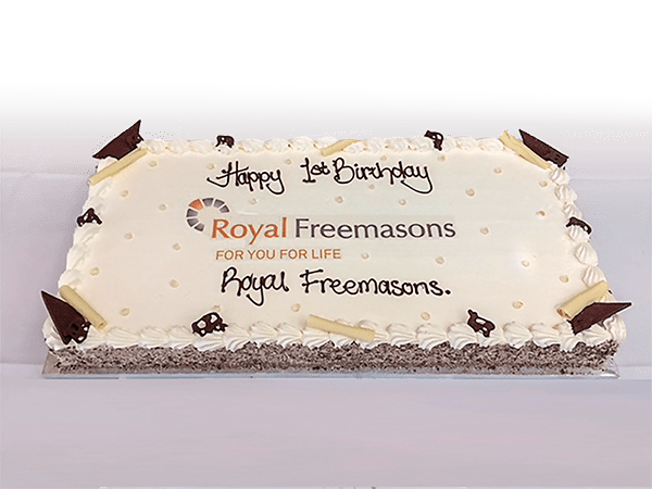 A birthday cake with "happy 1st birthday royal freemasons for you for life" written in icing.