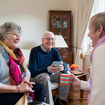 Group Of Senior Friends Meeting At Home For Coffee