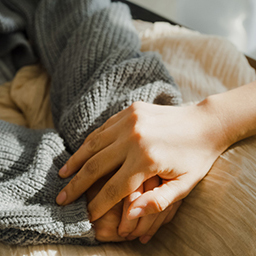 Closeup of young Asian people holding hands trust comfort help cancer patients talk crying stress relief in living room at home. Healthcare.