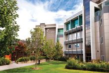 Modern residential building with landscaped garden on a clear day.