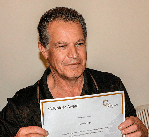 Man holding a 'volunteer award' certificate with a sense of pride.