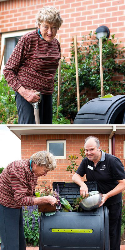An elderly person gardening and composting with assistance from a staff member.