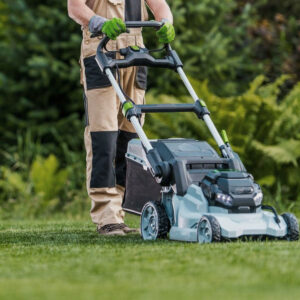 Gardener Trimming Grass Lawn Using Electric Cordless Mower